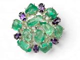 un gros plan d'une broche verte et violette posée sur une surface blanche