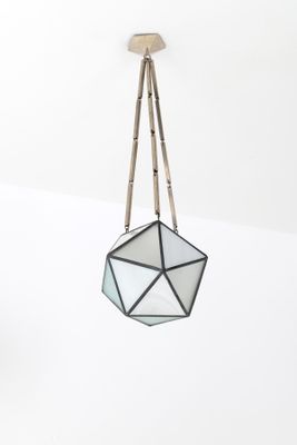La jardinière suspendue en verre est accrochée au plafond dans une pièce blanche