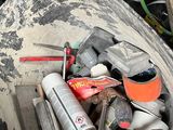 a bucket full of assorted items sitting on the floor