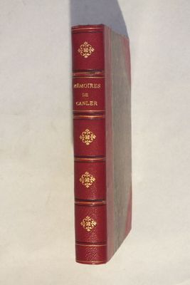 un vieux livre rouge posé sur une table blanche
