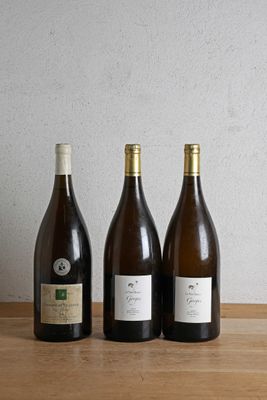 three bottles of wine are lined up on a wooden table