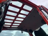 a close up of a red jeep with a basket on the roof