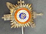 un insigne orné d'une étoile sur un fond gris