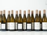 six bouteilles de vin sont alignées sur une table