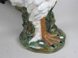 a white bird that is sitting on top of a vase