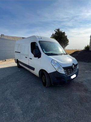 une camionnette blanche garée sur un parking à côté d'un bâtiment