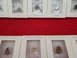 six boxes of different types of ear buds on a red surface