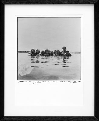 black and white photograph of a group of people floating in a body of water