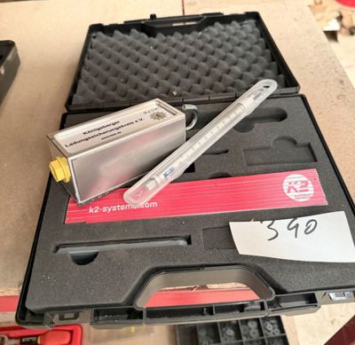 une boîte contenant un stylo et un outil, posée sur une table