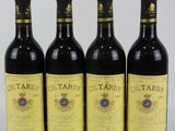 quatre bouteilles de vin sont alignées sur une surface blanche