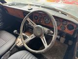 a steering wheel and dashboard of a car in a junkyard