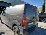 a silver van parked in a parking lot next to a building