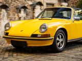a yellow car that is parked on a cobblestone street