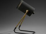 a black lamp on a metal stand with a black shade