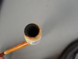 a person holding a pipe with a stick in their hand
