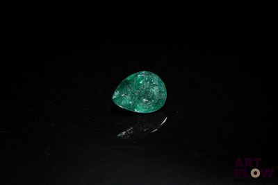 a close up of a green diamond on a black surface