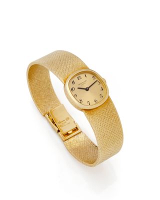 gros plan d'une montre-bracelet en or sur fond blanc