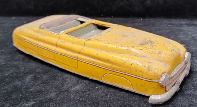 a yellow toy car that is sitting on a black surface