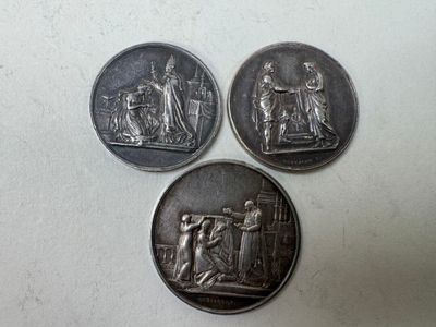 trois pièces d'argent sur lesquelles figurent les portraits d'une femme et d'un homme