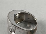 an image of a close up of a silver ring on a table