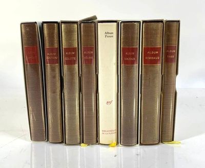 five books are lined up in a row on a white surface