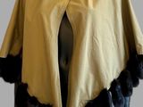 the mannequin is wearing a yellow cape with black furs