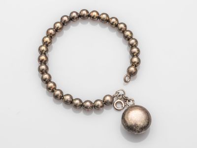 a close up of a bracelet with a ball on it