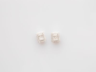 a pair of diamond earrings on a white background