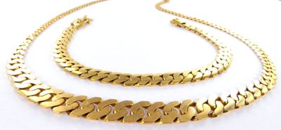 a close up of two gold chains on a white surface