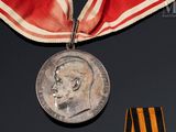 une médaille entourée d'un ruban sur lequel est représenté le visage d'un homme