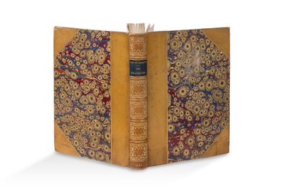 un vieux livre ouvert, dont la couverture laisse apparaître un motif décoratif