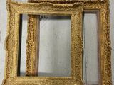 two gold framed mirrors sitting on top of a white wooden floor