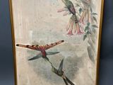 une image représentant un tableau sur lequel figurent deux colibris et une fleur, dans un cadre doré