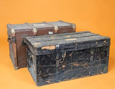 two old trunks sitting next to each other on a yellow background