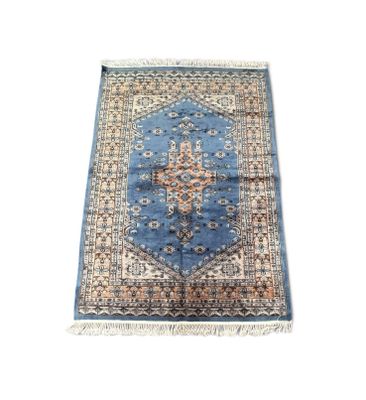 une image représentant un tapis bleu et beige sur fond blanc