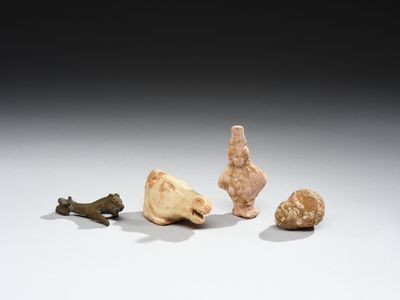 trois petites figurines représentant des animaux et un oiseau, posées sur une surface blanche