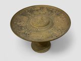 an antique brass plate with a circular design on it