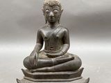 statue représentant une personne assise en position du lotus sur une table