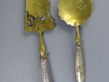 pair of silver plated serving utensils and a spoon