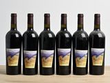 six bouteilles de vin sont alignées sur une table en bois