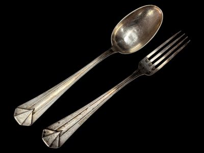 two spoons and a fork on a black background