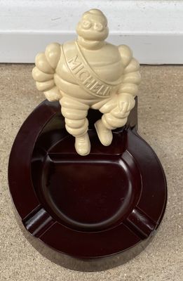une petite statue représentant un homme posée sur un cendrier