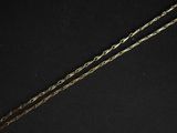 un gros plan d'un collier avec une chaîne en or sur fond noir