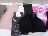 a lot of clothes and a bra top on a table