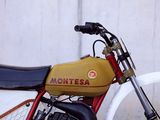 a red and yellow motorcycle parked next to a white wall