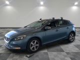 La voiture bleue est garée sur le sol à damier du garage.