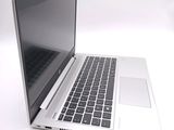a silver laptop computer sitting on a white surface
