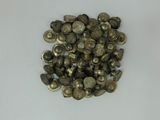 a close up of a pile of metal buttons on a white surface