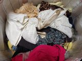 a basket full of clothes that is sitting on the floor
