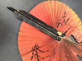 a pair of scissors and a paper fan on a table
